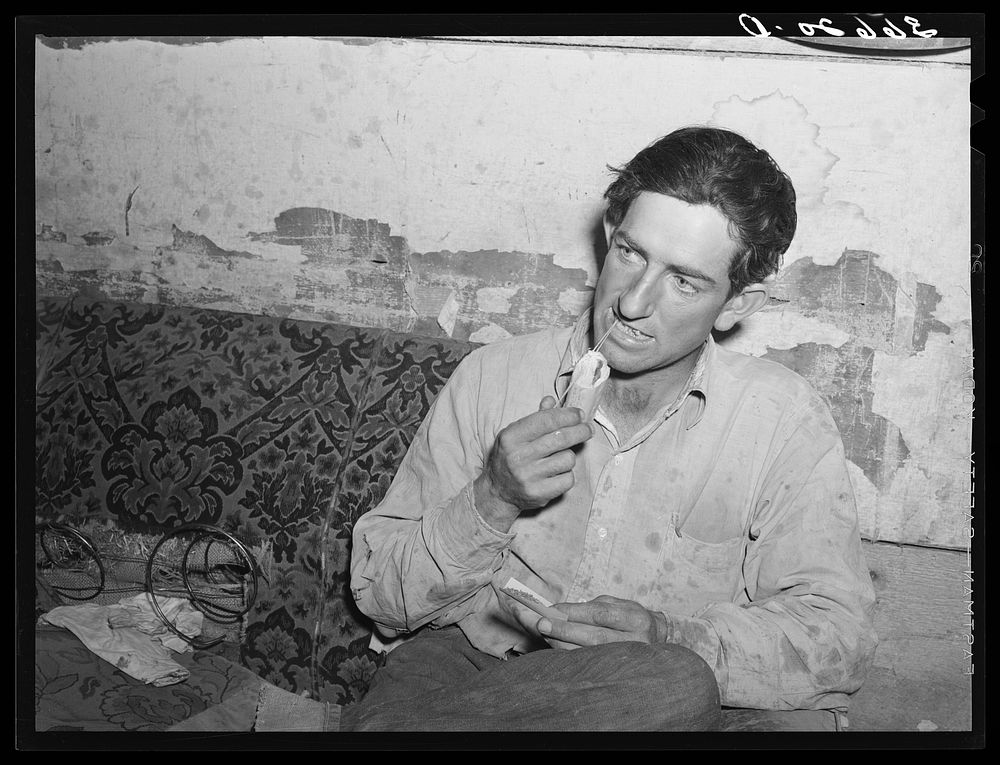 Faro Caudill, homesteader, rolling a cigarette. Pie Town, New Mexico by Russell Lee