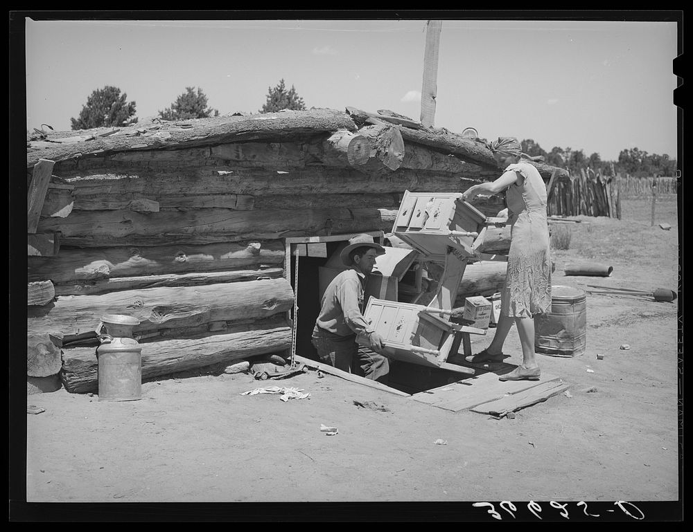 Mr. and Mrs. Caudill moving furniture from their dugout. Pie Town, New Mexico by Russell Lee