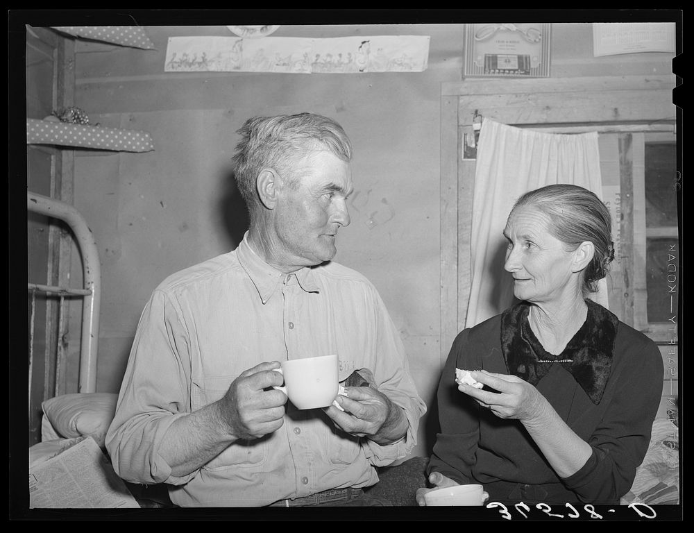 Mr. and Mrs. Besson eating cake and coffee at a Forty-two party at their home. Pie Town, New Mexico. They farmed in Oklahoma…