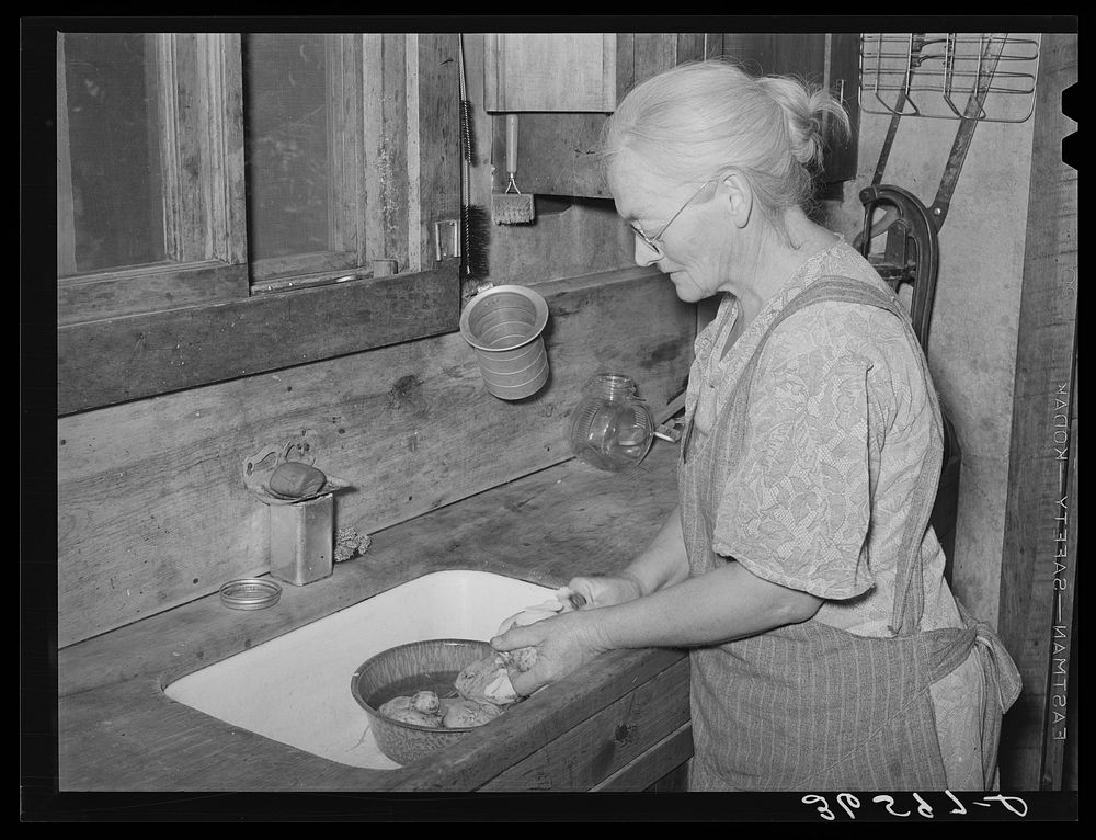Homesteader's wife peeling potatoes for dinner. Pie Town, New Mexico by Russell Lee