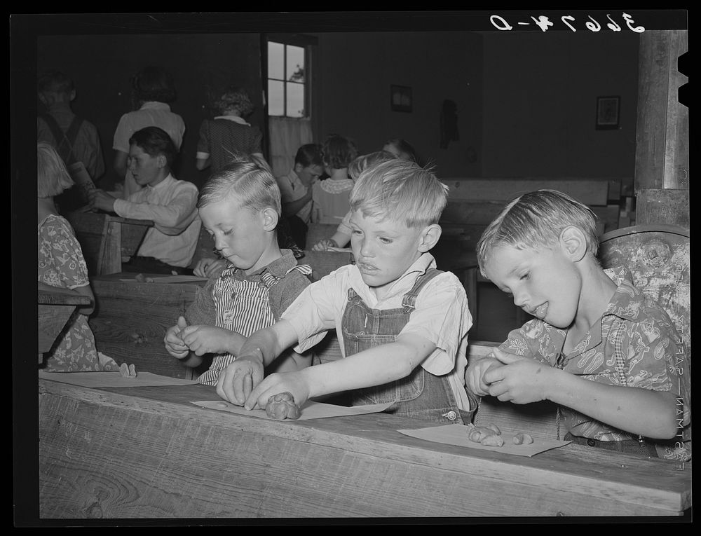 Youngsters modeling in clay at the private school in the Farm Bureau building. Pie Town, New Mexico by Russell Lee