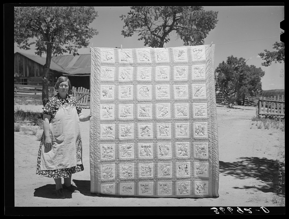 Mrs. Bill Stagg with state quilt she made. Mrs. Stagg helps her husband in the fields with plowing, planting, and weeding…