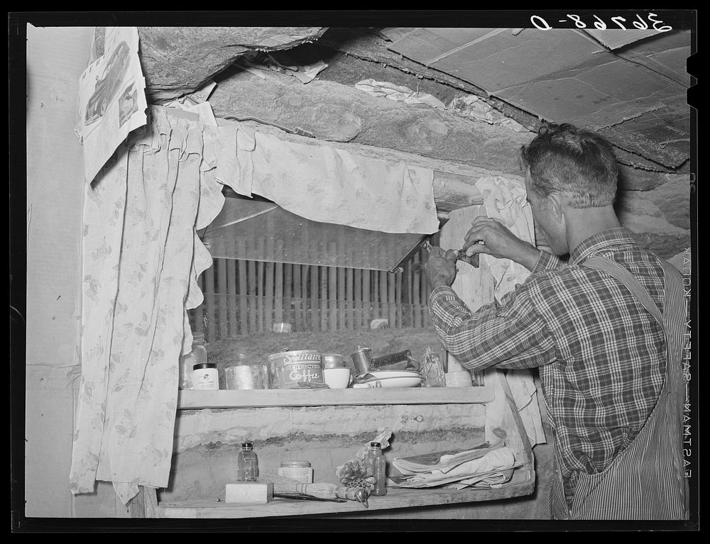 Jack Whinery does some repair work on the window in his dugout. The window was made from the windshield of the worn-out car…