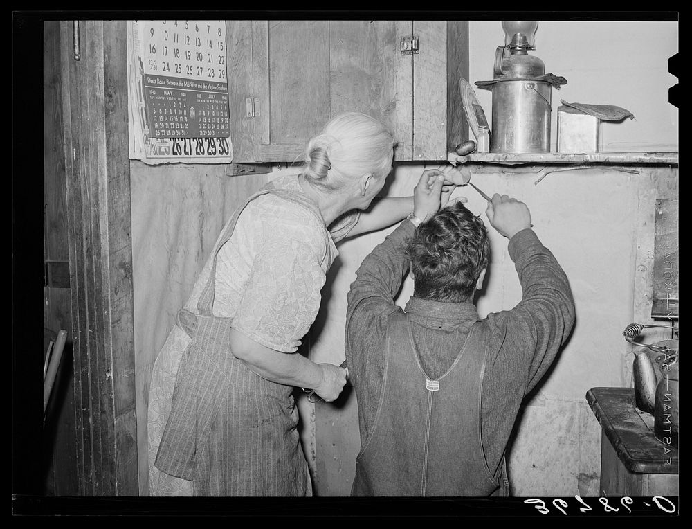 Mrs. Hutton and her son papering the kitchen. Pie Town, New Mexico by Russell Lee