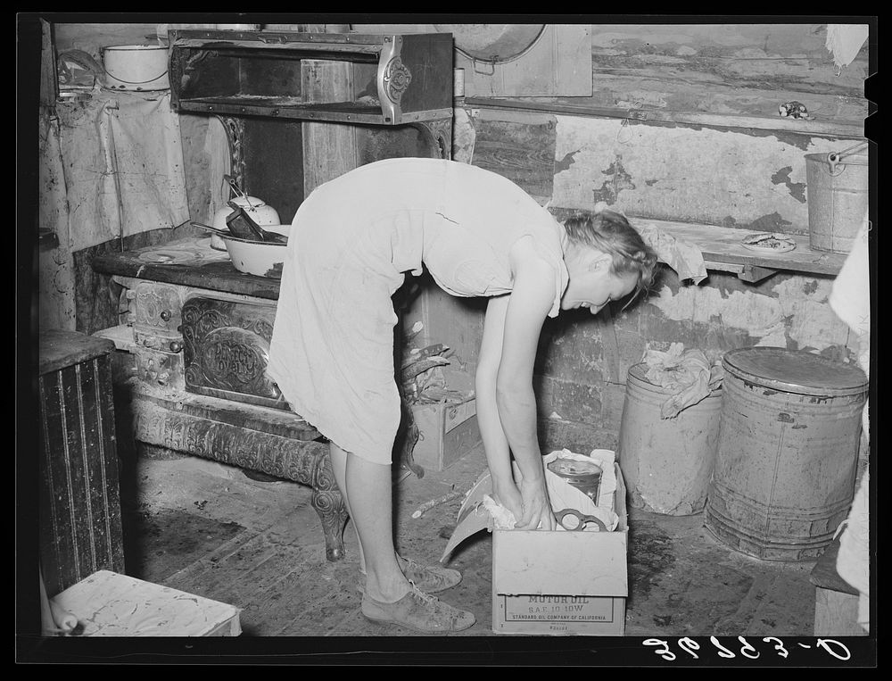 [Untitled photo, possibly related to: Mrs. Faro Caudill packing up kitchen equipment for moving to new dugout nearer the…