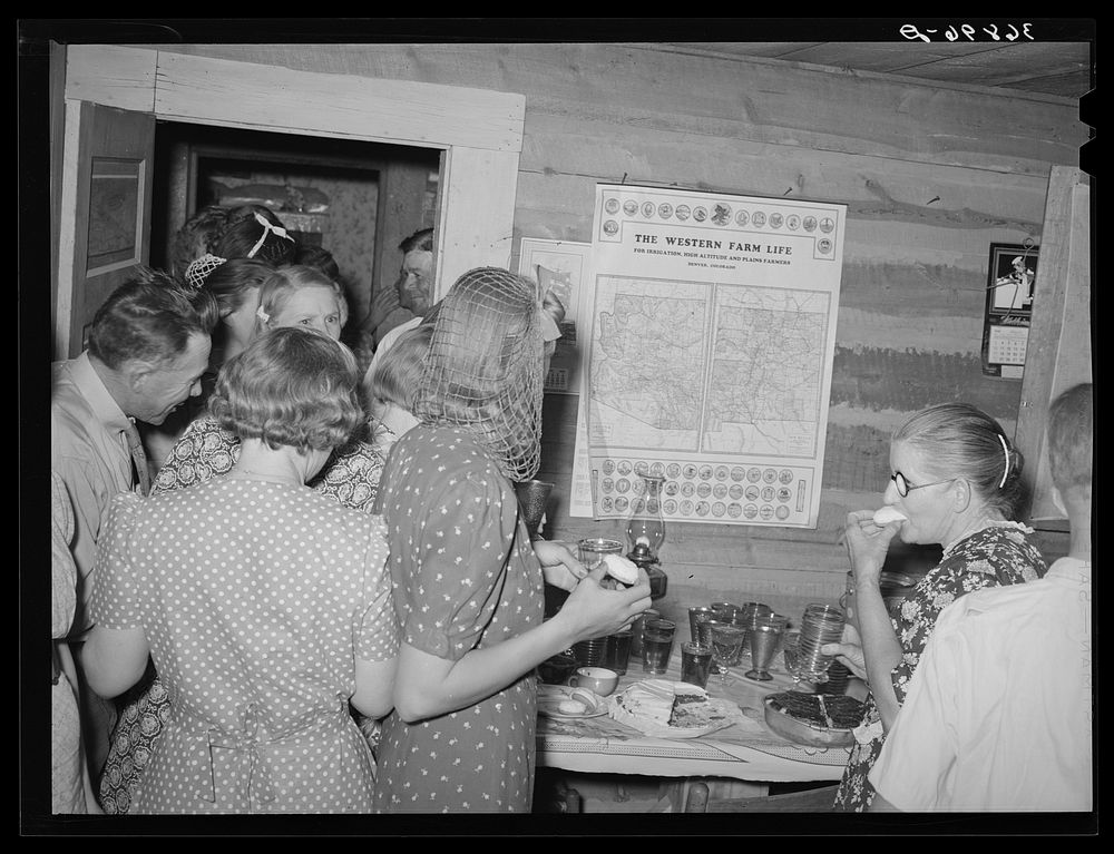 The dancers gather around for refreshments at the square dance. Pie Town, New Mexico by Russell Lee