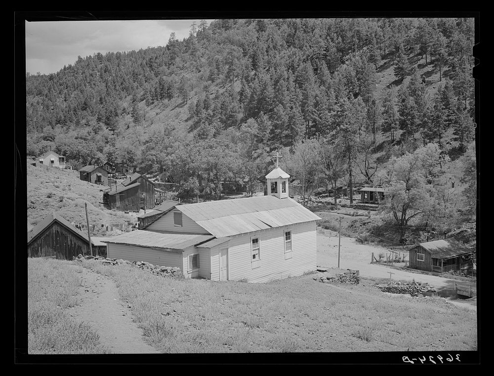 Church surrounded by miners' homes. Mogollon, New Mexico by Russell Lee