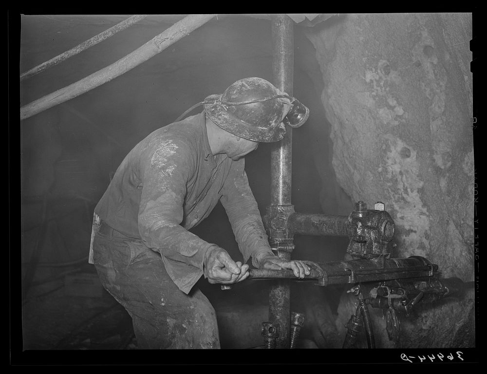 Gold miner operating pneumatic drill at Mogollon, New Mexico by Russell Lee