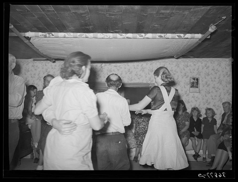 Figure in a square dance. Pie Town, New Mexico. Notice the quilting frame overhead by Russell Lee