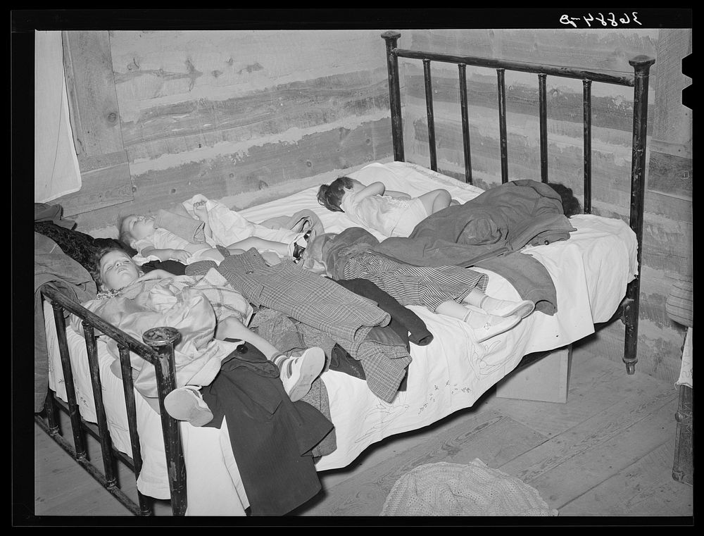Children asleep while their parents square dance. Pie Town, New Mexico by Russell Lee