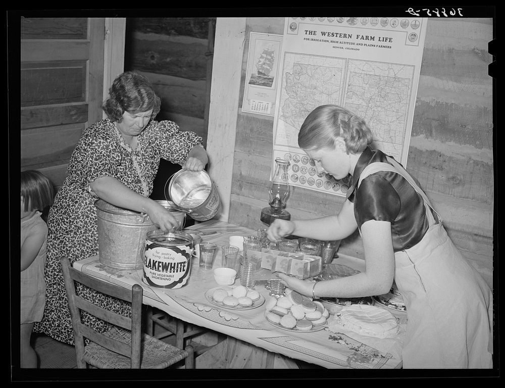 Putting out the refreshments, cakes, cookies and lemonade at the square dance. Pie Town, New Mexico by Russell Lee