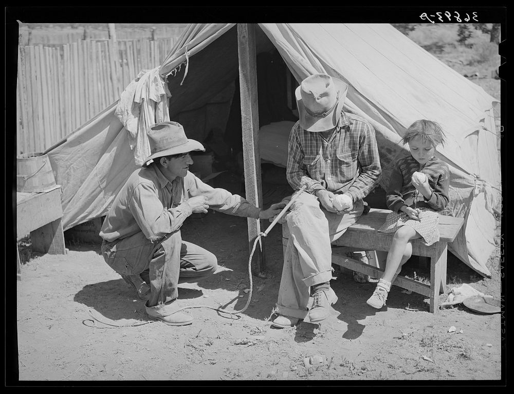 Faro Caudill, left, John Adams, center, and Josie Caudill, right, in front of the Caudill tent in which they are living for…