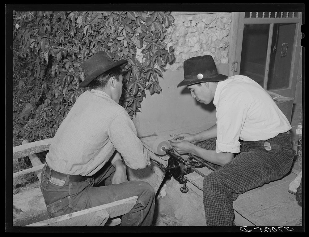 Spanish-American boy sharpening knife. Chamisal, New Mexico by Russell Lee