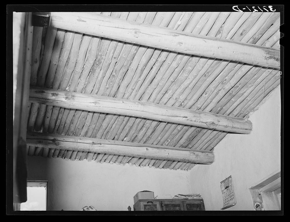 Vigas in Spanish-American home. This is regular ceiling construction on adobe houses. Amalia, New Mexico by Russell Lee