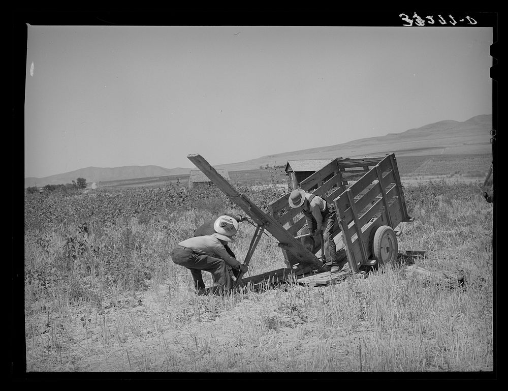 Unloading FSA (Farm Security Administration) cooperative ditcher from trailer. Box Elder County, Utah by Russell Lee