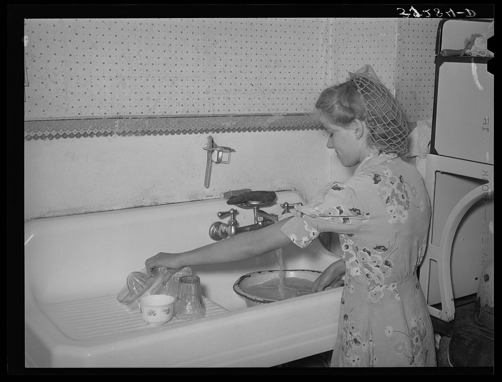 Daughter of Mormon farmer washing dishes. In most of the Mormon communities running culinary water is common. Snowville…