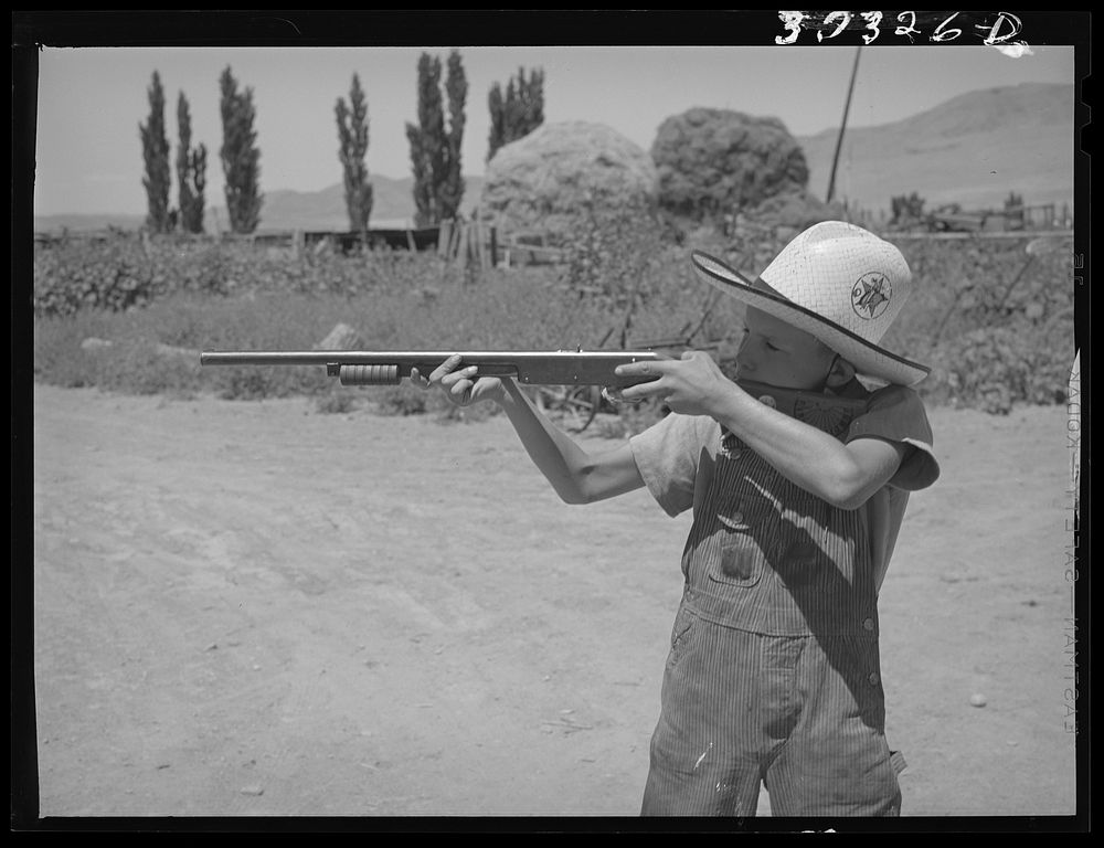 Mormon farm boy shooting air rifle. Box Elder County, Utah by Russell Lee