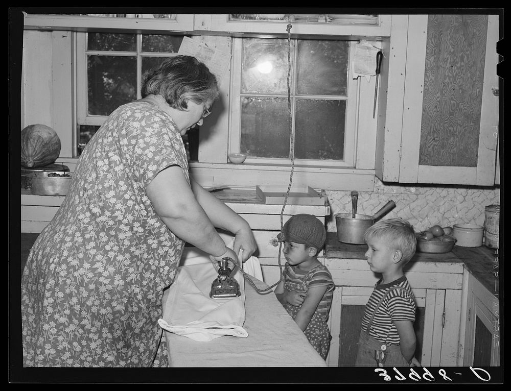 Mrs. J. Webster ironing while her sons look on. Tehama County, California by Russell Lee