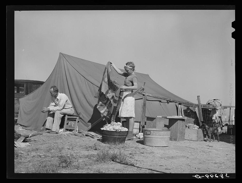 Roofer and his daughter in front of tent home. Corpus Christi, Texas. This man has been working at the naval air training…