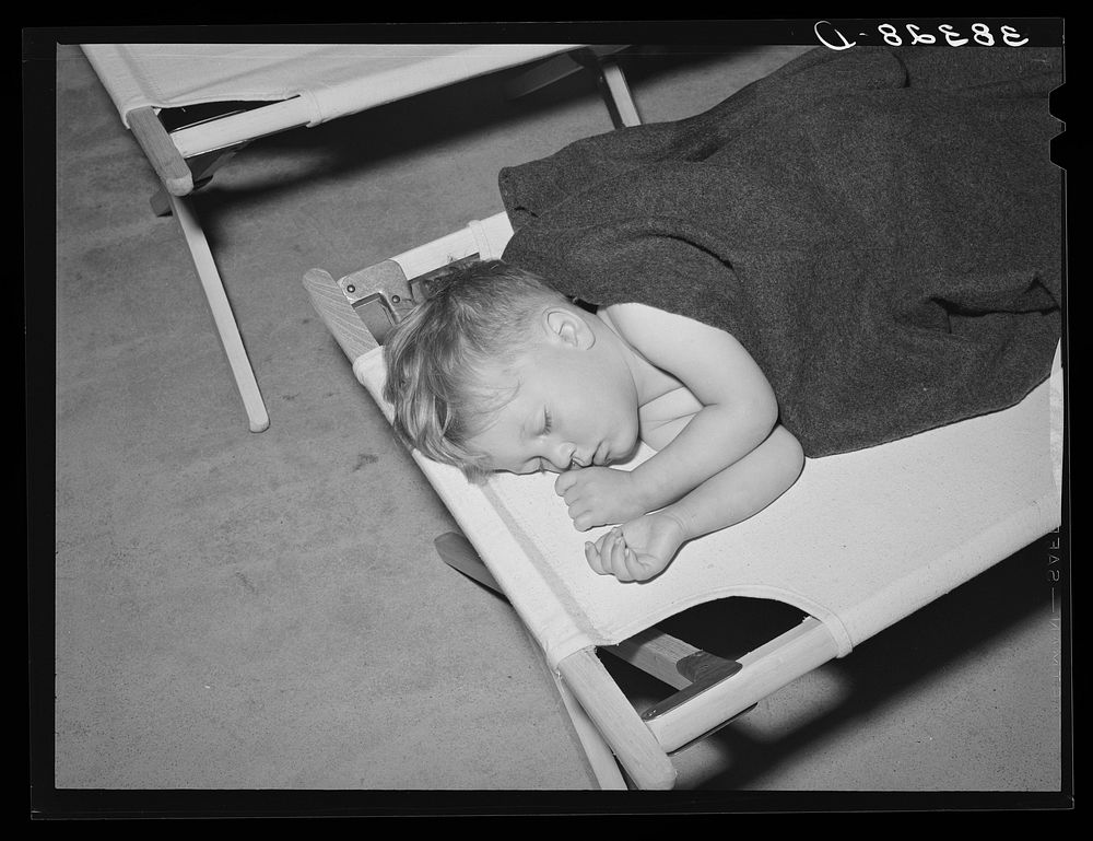 Boy asleep in community building of the Yuba City farm workers' camp. Yuba City, California by Russell Lee