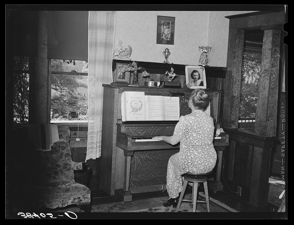Fruit farmer's wife playing piano. Placer County, California. Because they have not changed the variety of plums and pears…