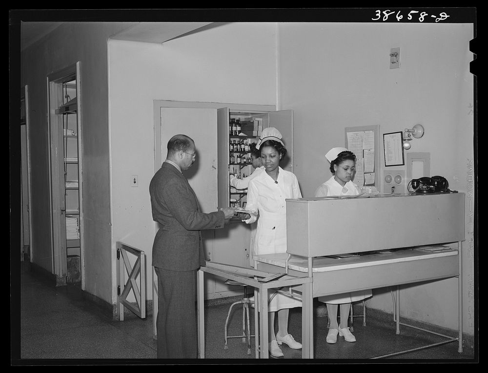 Doctor getting charts from head nurse at  hospital. Chicago, Illinois by Russell Lee