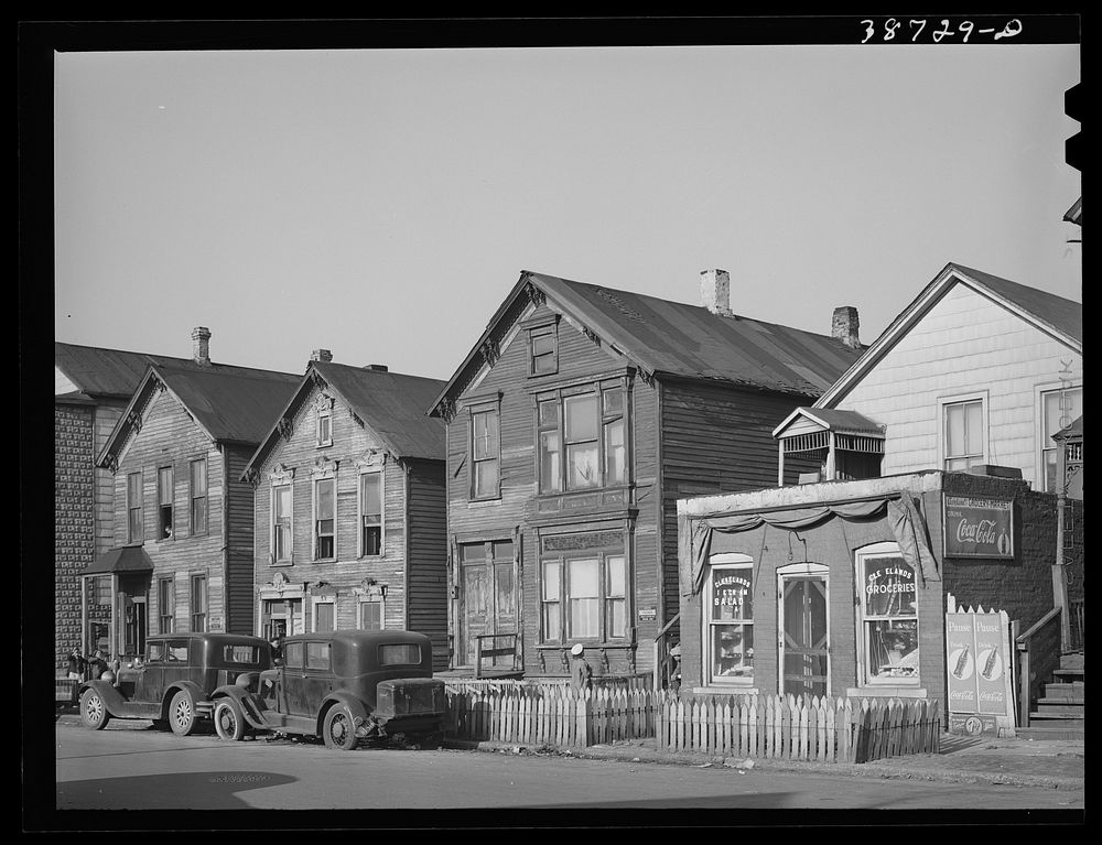 [Untitled photo, possibly related to: Houses and grocery store on Federal Street in the African American section of Chicago…