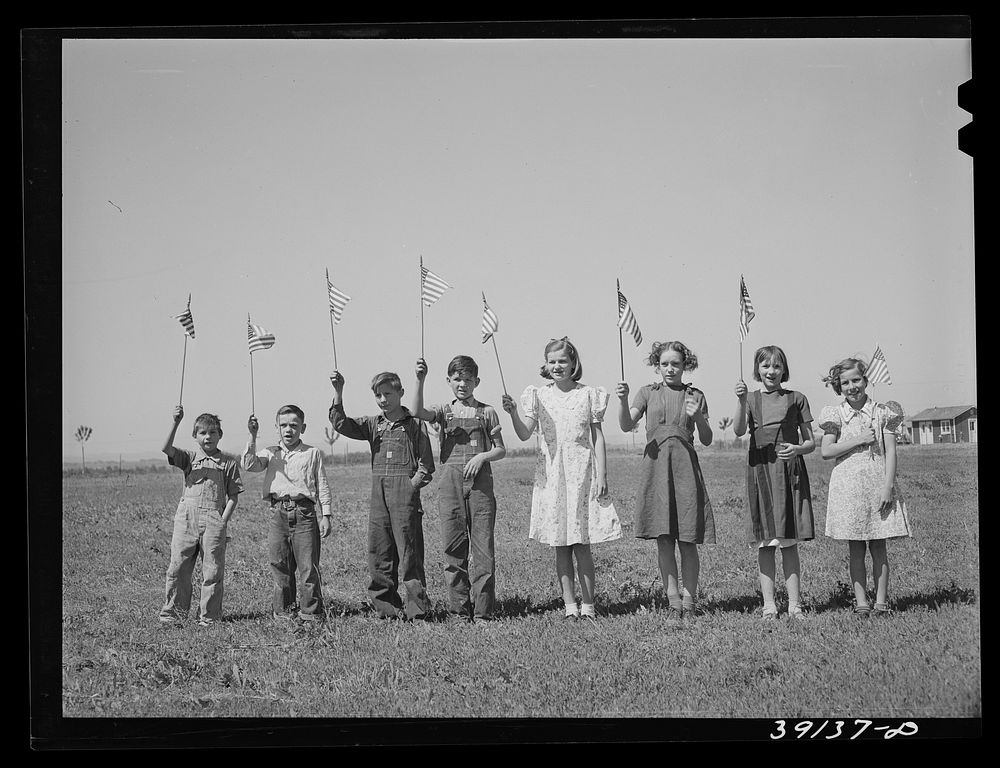 Flag drill for entertainment at end of school term at the FSA (Farm Security Administration) camp for farm workers.…