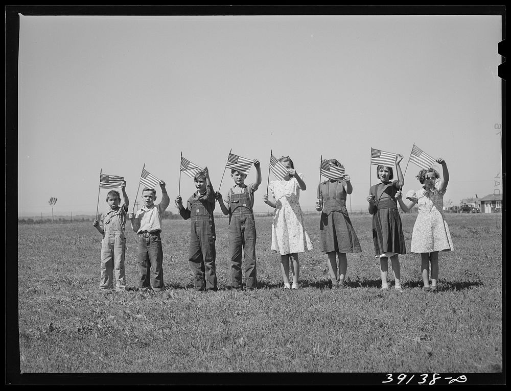 Flag drill for entertainment at end of school term at the FSA (Farm Security Administration) camp for farm workers.…