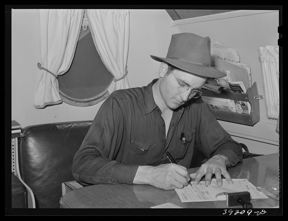 Camp manager in trailer office at the FSA (Farm Security Administration) migratory labor camp mobile unit. Wilder, Idaho by…