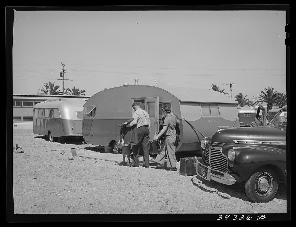 Family moving into trailer at the FSA (Farm Security Administration) camp for defense workers. Before moving to the FSA camp…