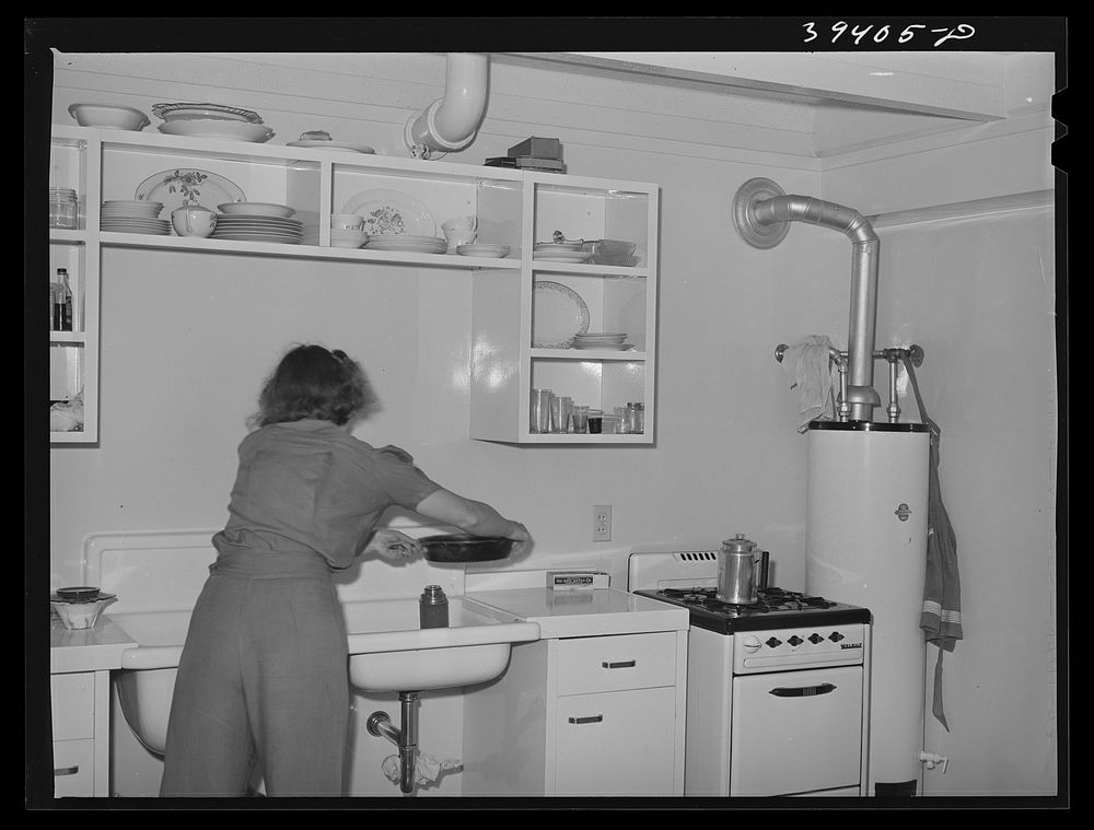 Wife of Marine washing dishes. They live in one of the units of the Navy defense housing project. San Diego, California by…