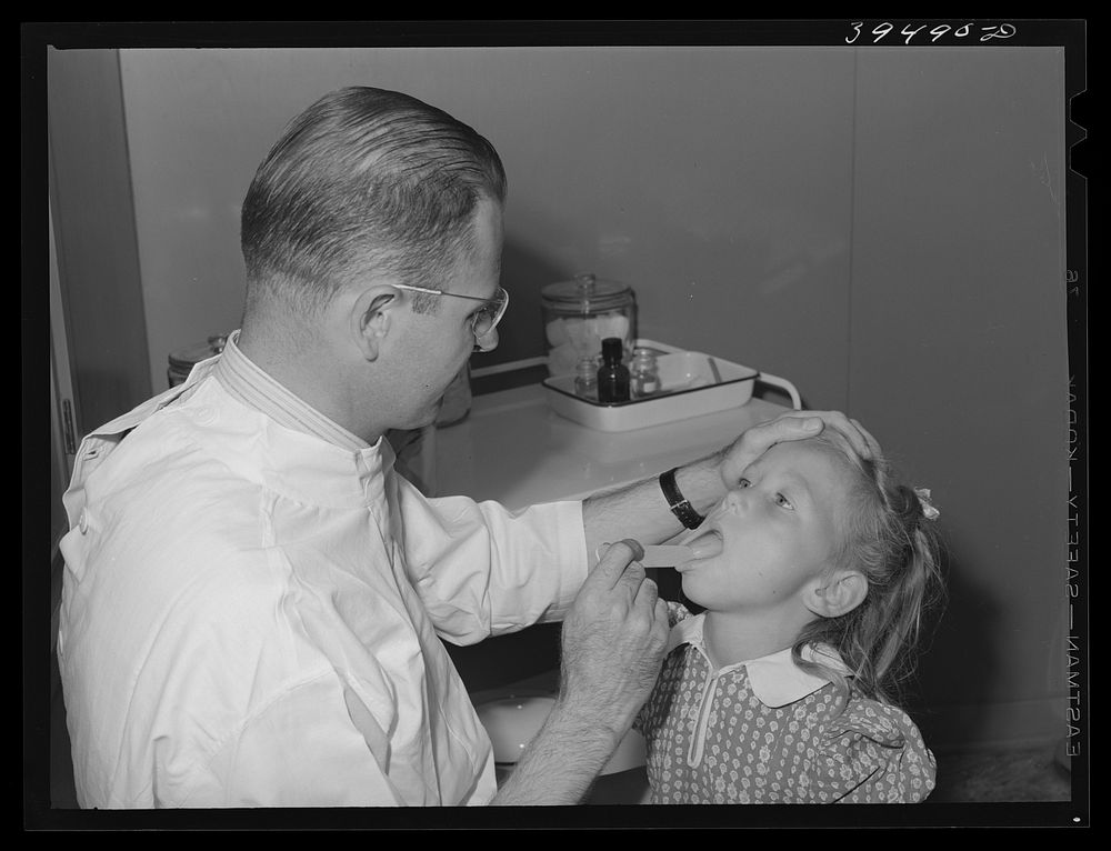 Doctor examines daughter of farm worker living at the FSA (Farm Security Administration) labor camp. Caldwell, Idaho by…