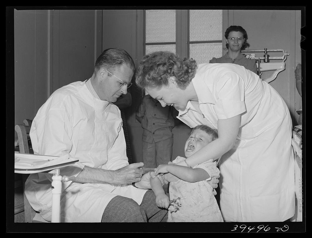 Doctor and nurse give daughter of farm worker tick fever serum at the FSA (Farm Security Administration) labor camp.…