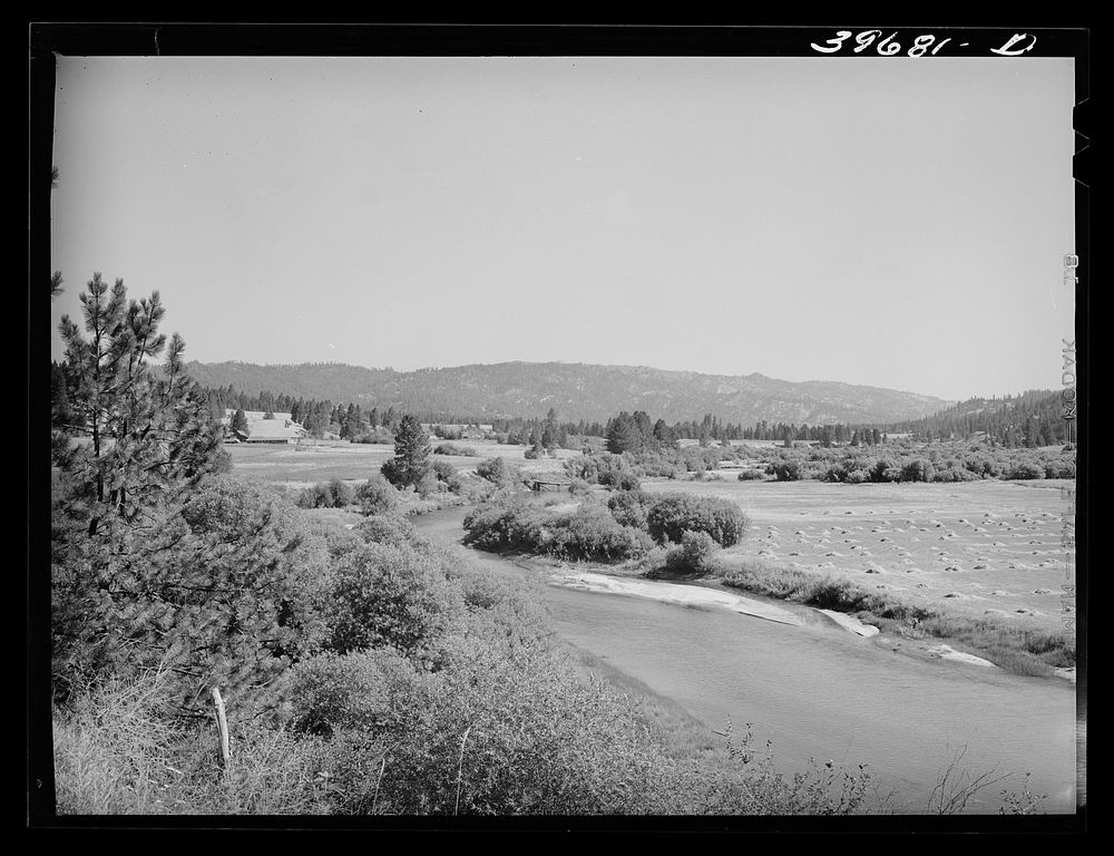 Scene in Garden Valley, Boise County, Idaho. The valley is lush and green, spotted with small farms and the many hay fields…