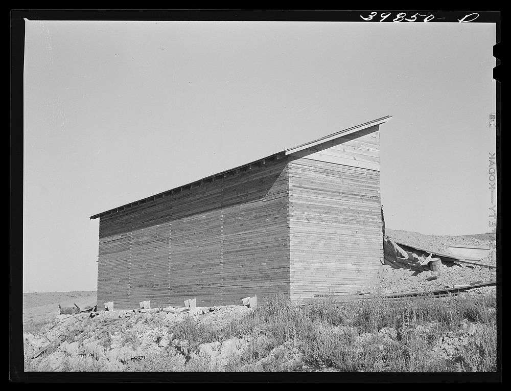 Bulk wheat elevator on farm. This elevator was built from plans drawn up and furnished by the State Extension Service and…