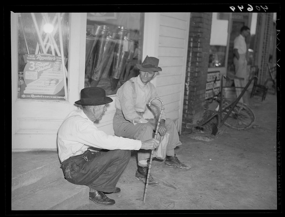 Men discussing the election on steps of general store in Stem, Granville County, North Carolina. Sourced from the Library of…