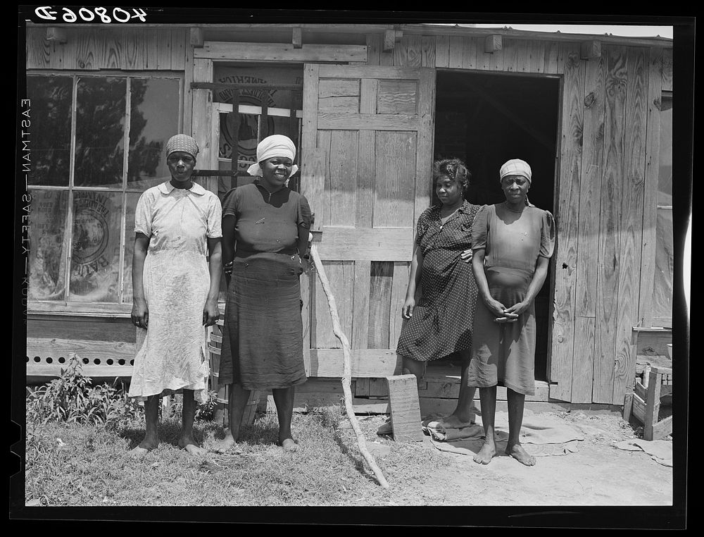 Group of migratory agricultural workers from Florida outside their shack on potato field near Belcross, North Carolina.…