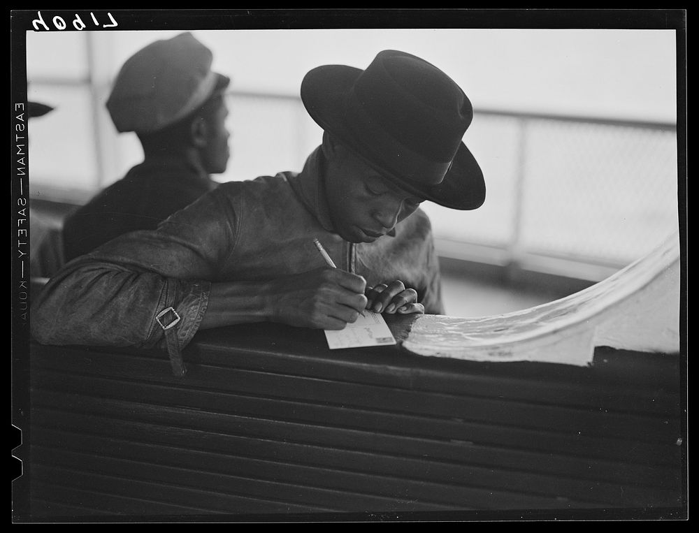 [Untitled photo, possibly related to: Migratory worker on the Norfolk-Cape Charles Ferry, writing a postcard home to his…