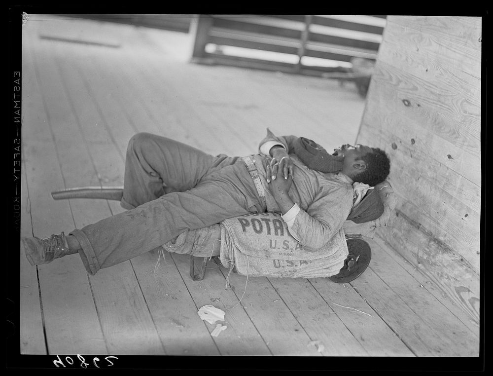 Migratory agricultural worker sleeping in grading station at Camden, North Carolina. Sourced from the Library of Congress.