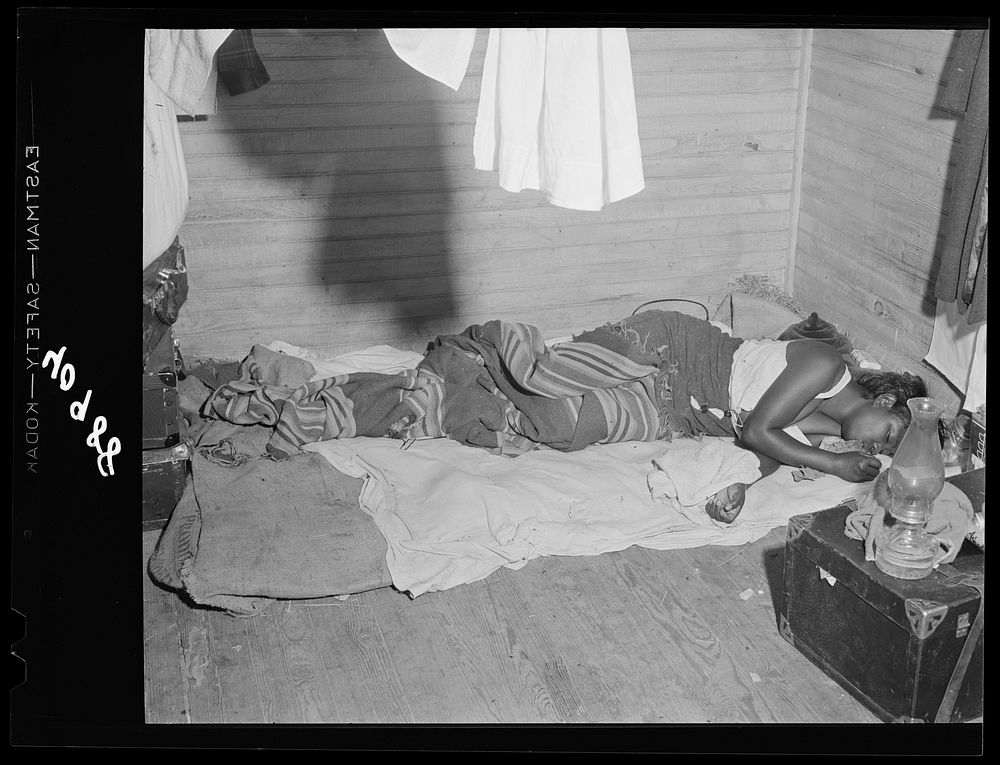 Belcross (vicinity), North Carolina. A girl sleeping in an old farmhouse which she shares with thirty-five other people.…