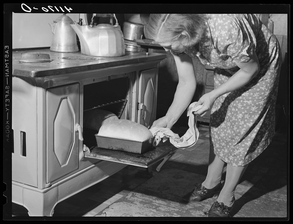 Mrs. Knees at oven, baking bread to be sold at farmers' market. Du Bois, near Penfield, Pennsylvania. Sourced from the…