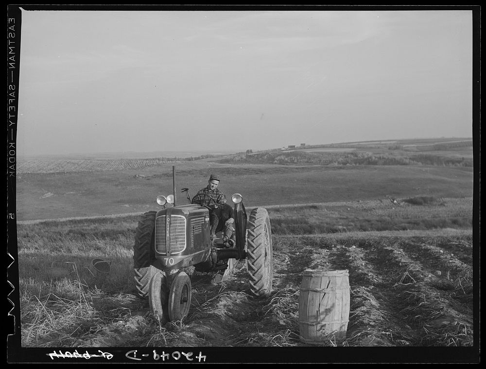 A community service tractor being operated. Claude Levesque on his farm near Van Buren, Maine. Sourced from the Library of…