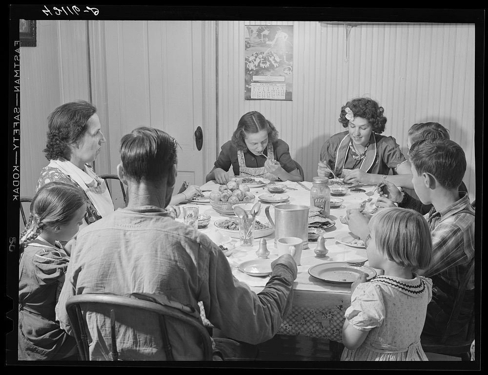 [Untitled photo, possibly related to: Dinner hour at the home of Mr. J.H. Dube, French-Canadian potato farmer, after he and…