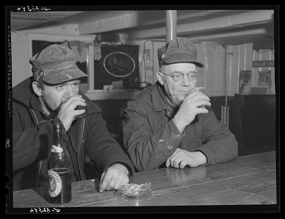 Shipyard workers stop in for a "beer" after work. In a bar just outside the Bath Iron Works. Bath, Maine. Sourced from the…