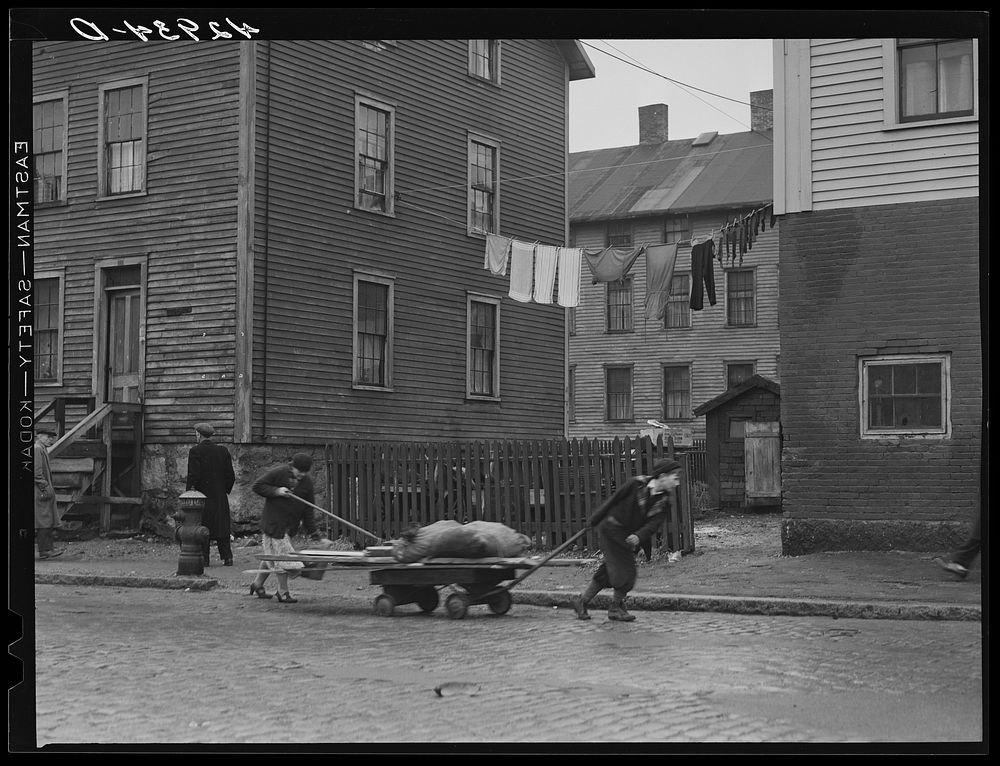 Bringing home some salvaged firewood in slum area in New Bedford, Massachusetts. Sourced from the Library of Congress.