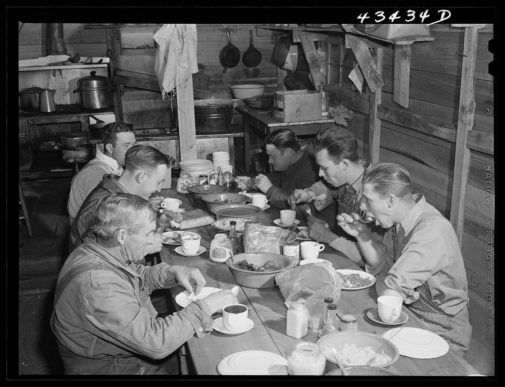 Migratory workers from Fort Bragg eating supper at a trailer settlement in Manchester, North Carolina. Sourced from the…