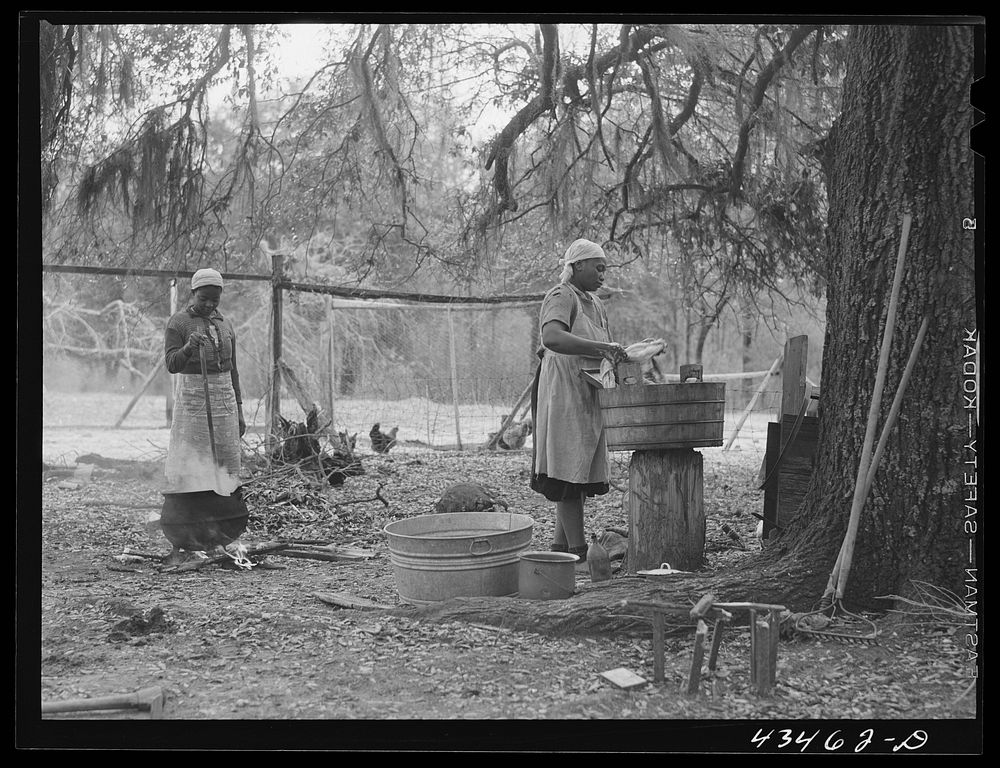 Family who had moved out of Santee-Cooper Basin, washing clothes on their "new" farm near Moncks Corner, South Carolina.…