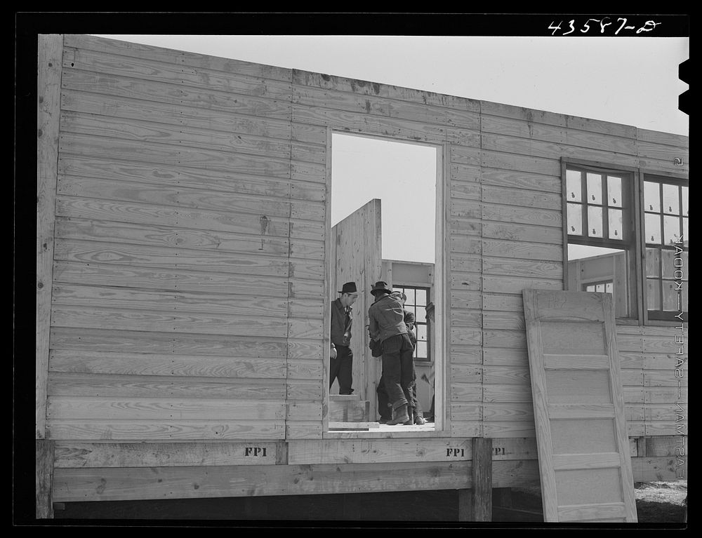 Putting up an inside wall in prefabricated houses for farmers moving out of the Camp Croft area. Pacolet, South Carolina.…