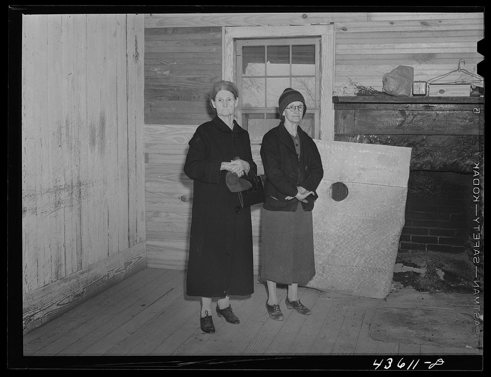 [Untitled photo, possibly related to: Mrs. Harvey and a neighbor watching her belongings being moved out of her house in the…